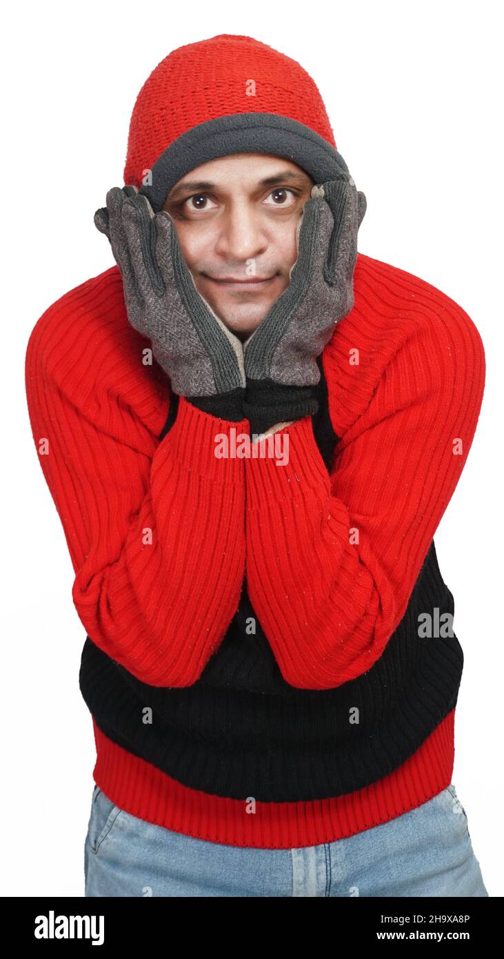 Young Indian Man Wearing a Woolen Sweater, Hand Gloves and Cap, Winter Season, Red and Black Sweater and Cap, Grey Hand Gloves, isolated in White Back Stock Photo