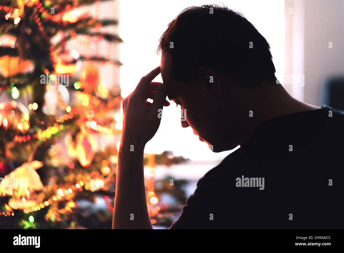 Sad on Christmas. Unhappy, lonely or tired man with stress, grief or depression. Family fight, loneliness, frustration or money problem on Xmas. Stock Photo