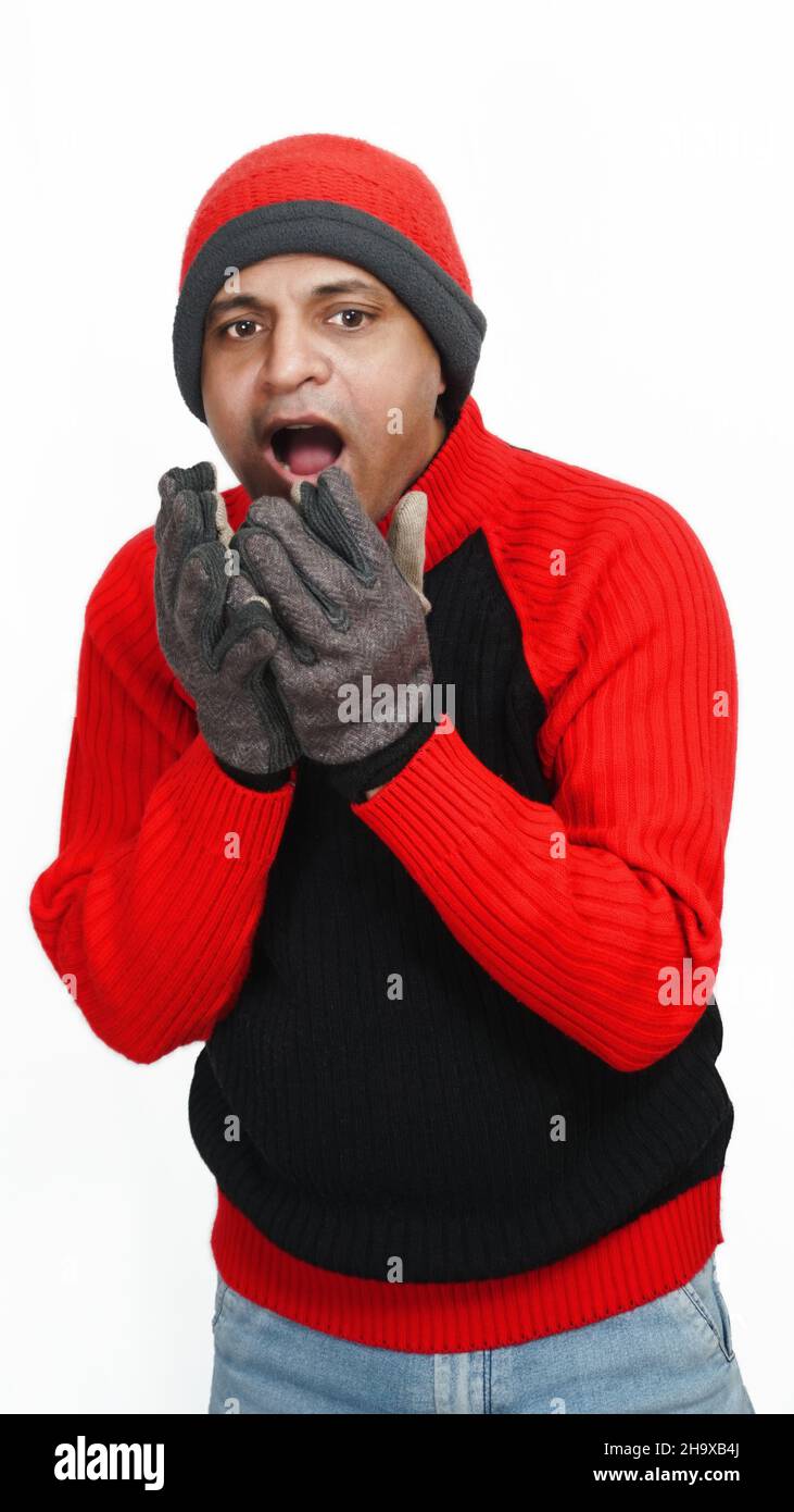 Young Indian Man Wearing a Woolen Sweater, Hand Gloves and Cap, Winter Season, Red and Black Sweater and Cap, Grey Hand Gloves, isolated in White Back Stock Photo
