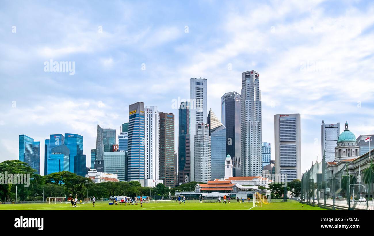 Padang, Singapore playing field of historic events. With the Financial Centre, Former Supreme Court, and Singapore Cricket  Club as background. Stock Photo