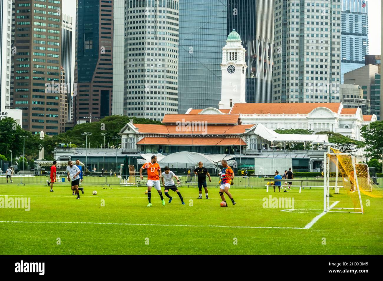 Foot ball activity on Padang field, with Singapore Cricket Club in the background Stock Photo