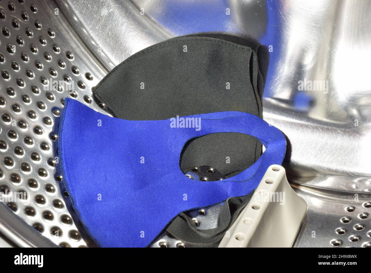 Two washed fabric medical face masks close up in the drum of the