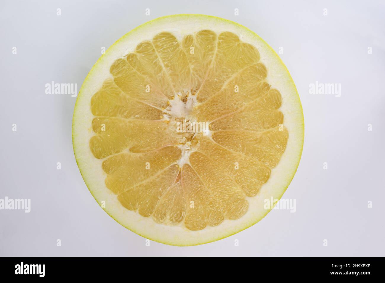 Pamelo fruit cut in half close up on white clipping background in middle of frame Stock Photo