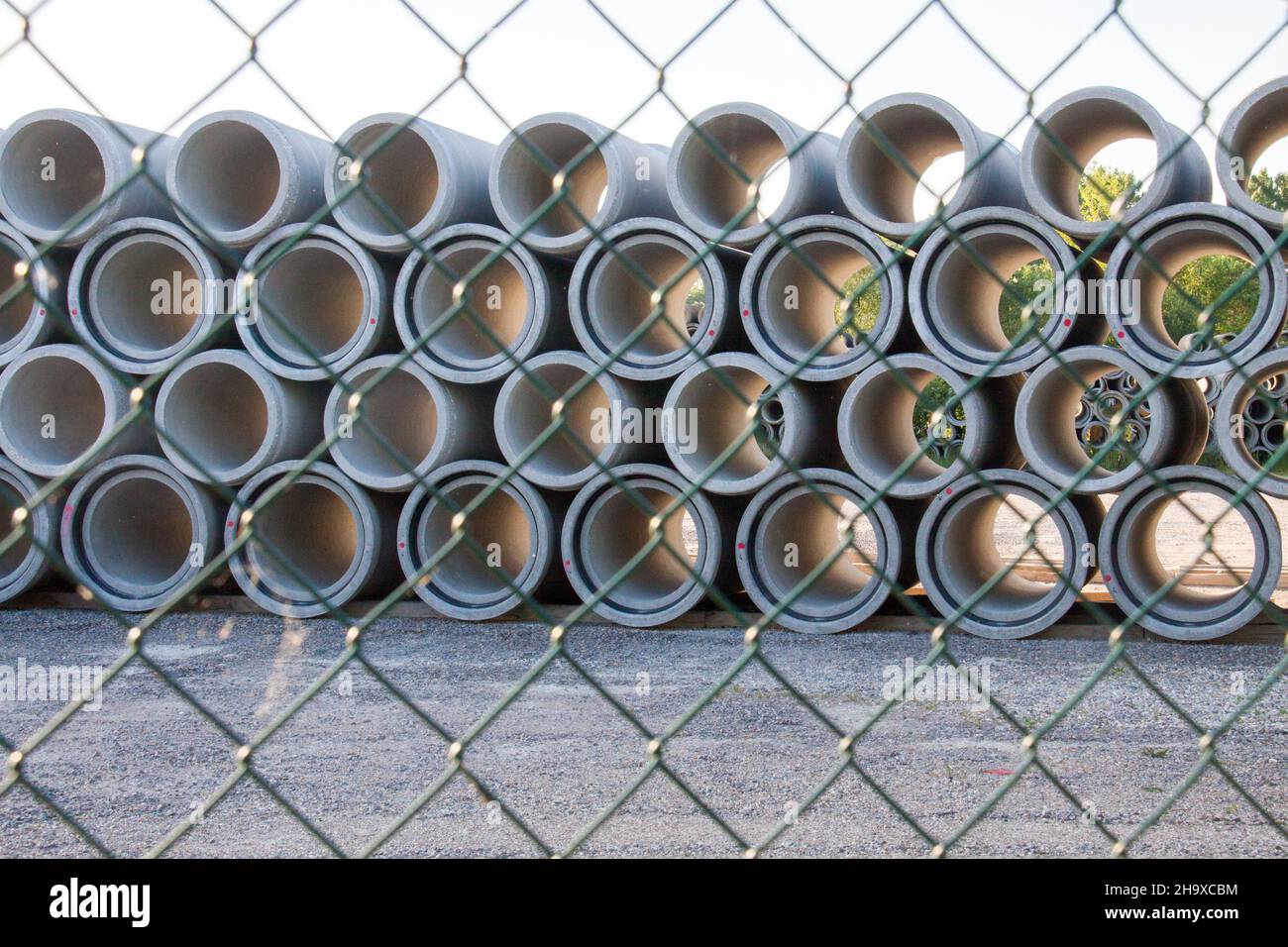 Stack of pipes behind a chainlink fence Stock Photo Alamy