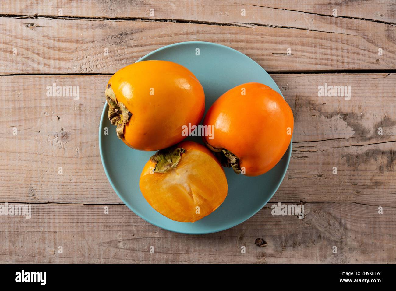 Fresh persimmon fruit on wooden table Stock Photo