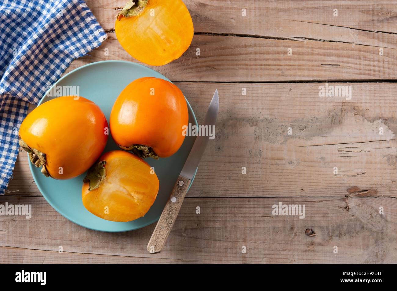 Fresh persimmon fruit on wooden table Stock Photo