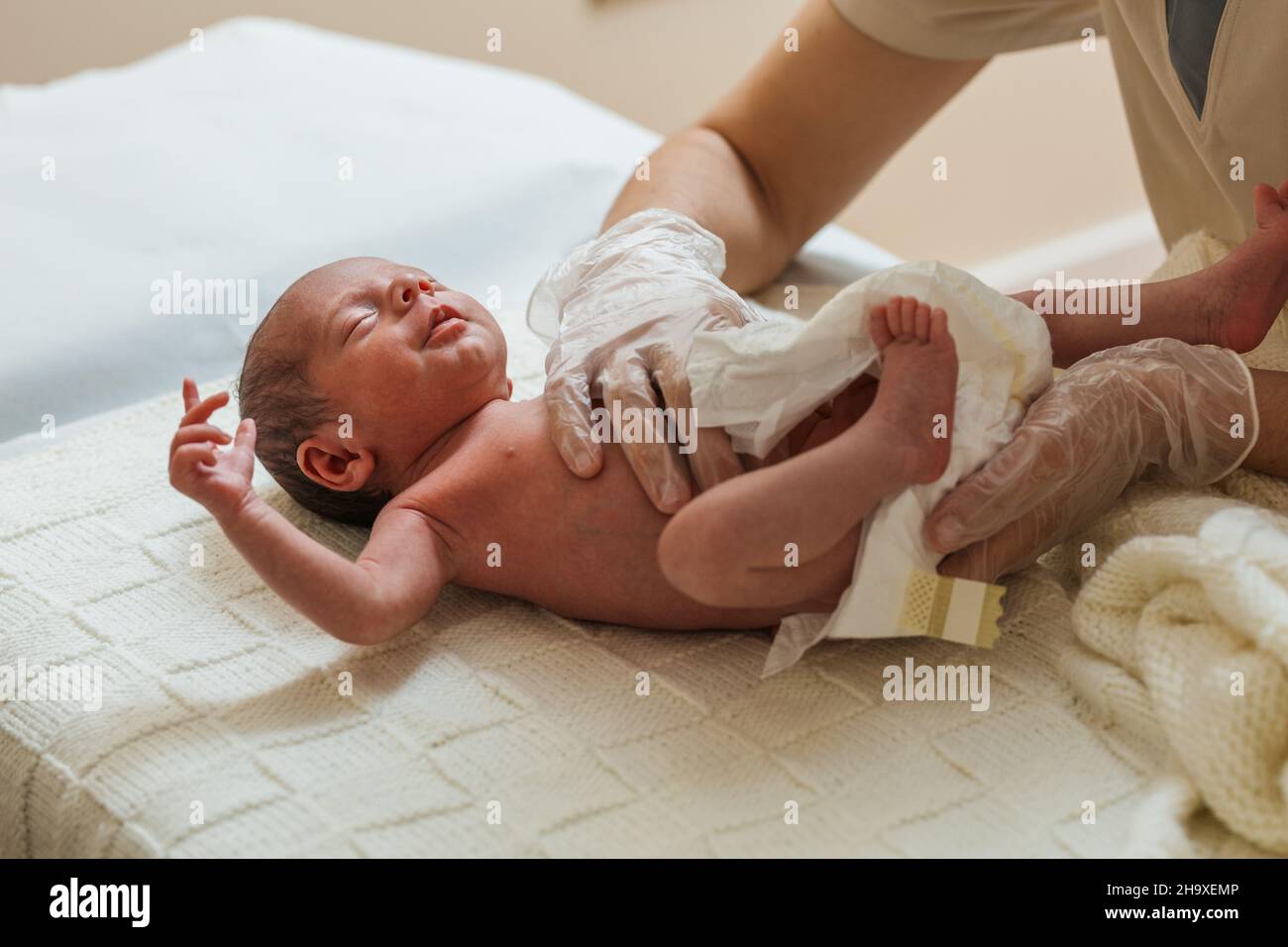 Professional physical therapist working with a newborn baby in a medical office. Stock Photo