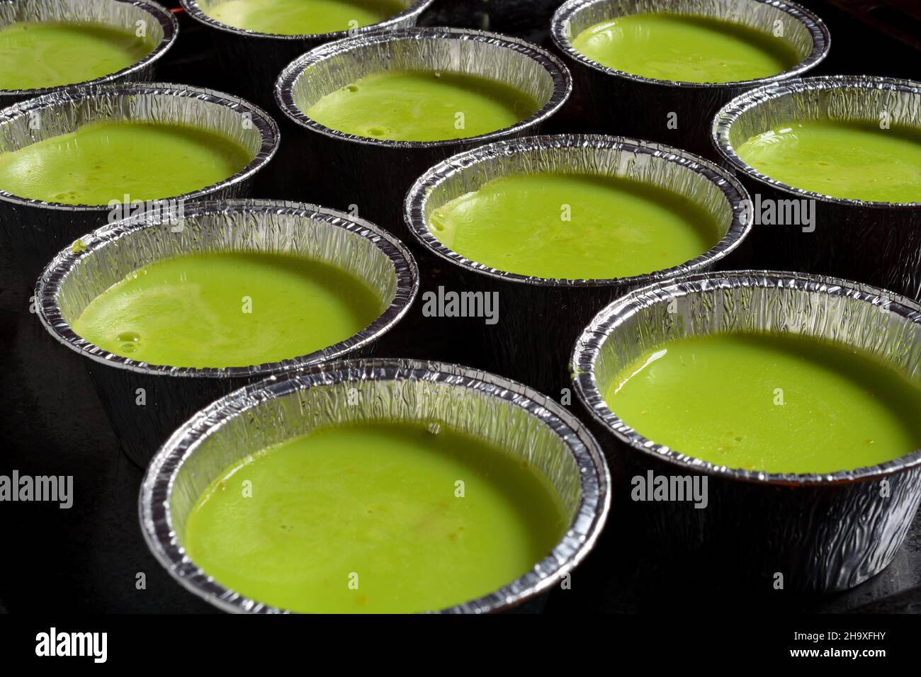 Pistachio puddings in aluminium foil moulds. Focus stacked images in order to get more DOF. Stock Photo