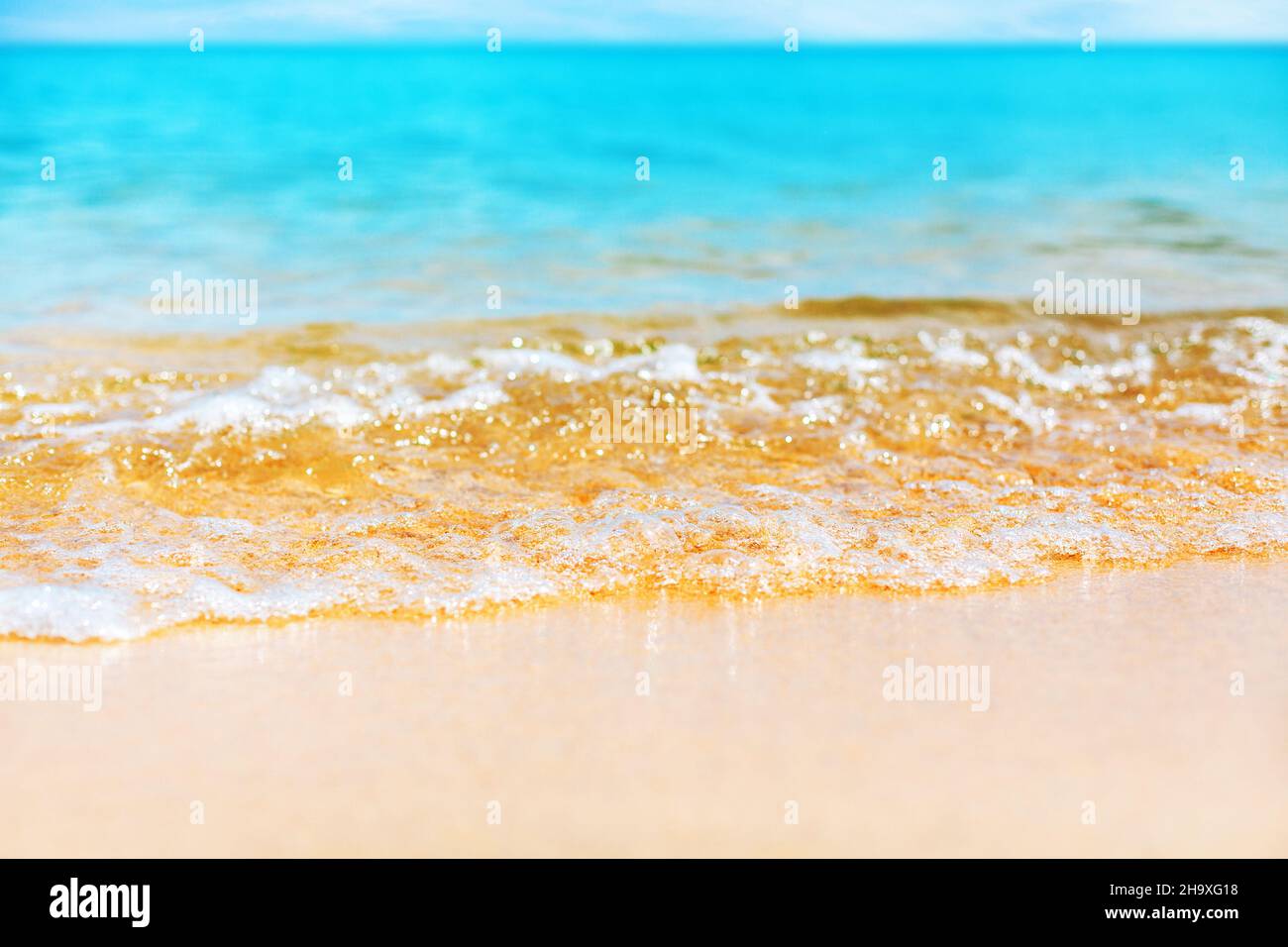 Blue sea wave splash closeup, ocean tide, turquoise water, white foam, golden yellow sand, sunny tropical island beach, natural background, summer Stock Photo