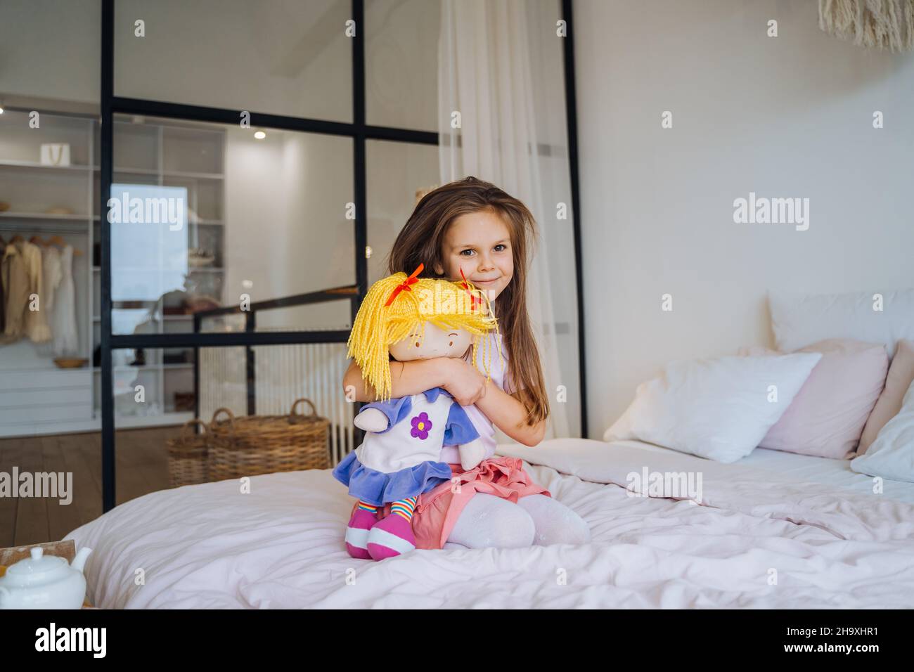 Cute smiling little girl child playing with her doll Stock Photo - Alamy