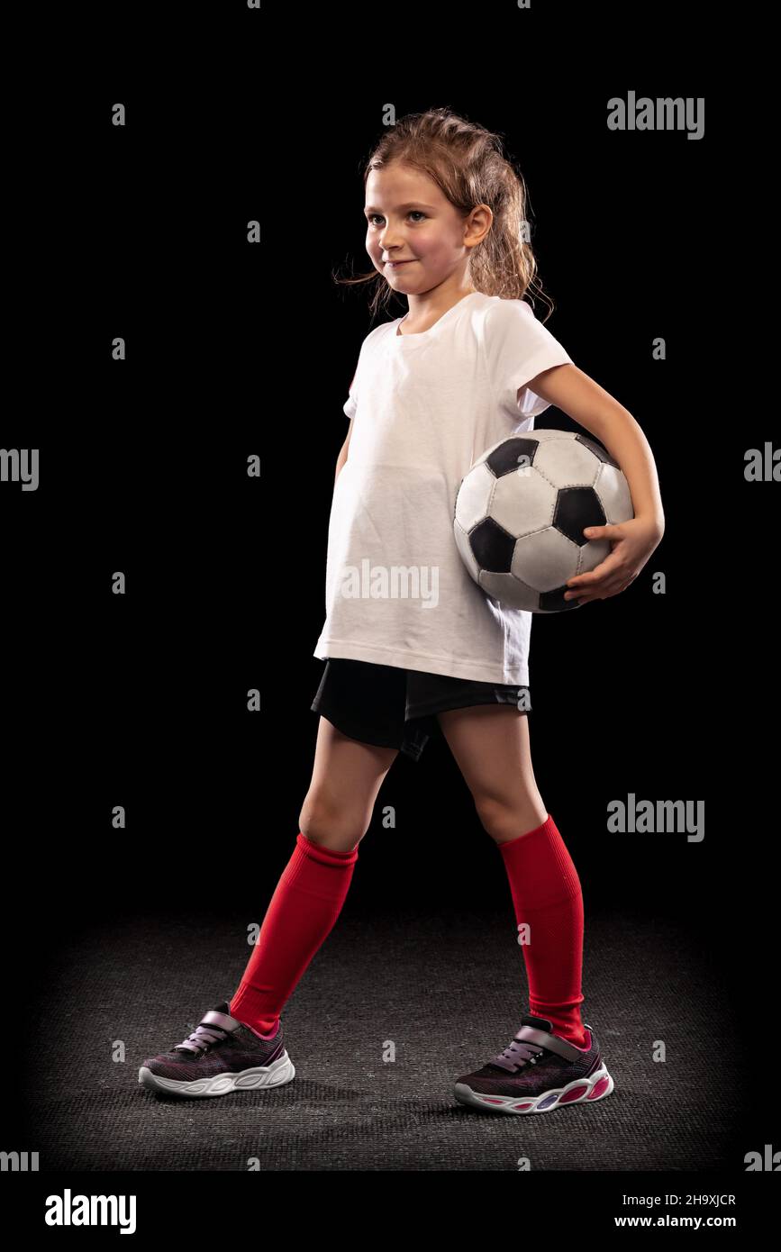 Portrait of little girl, football player uniform posing isolated over