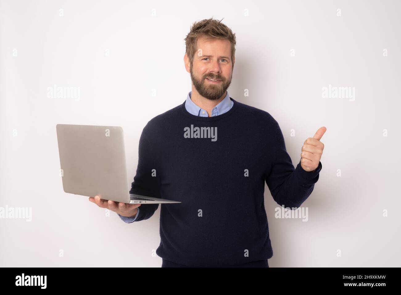 Young smiling handsome man holding laptop computer with thumb up ...