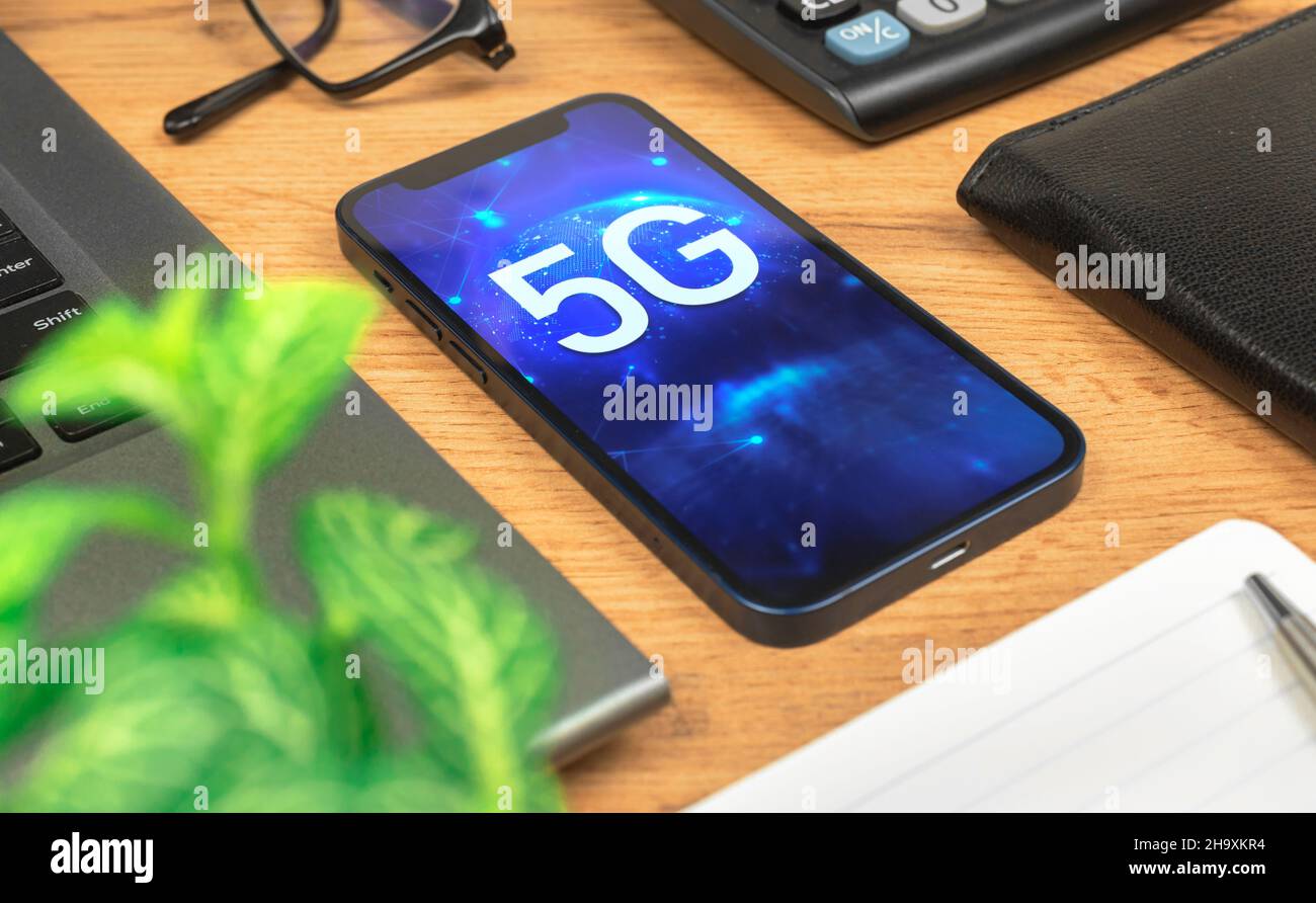 Phone with 5G network, hologram background. Business desktop. Concept of high speed internet, new generation of networks Stock Photo