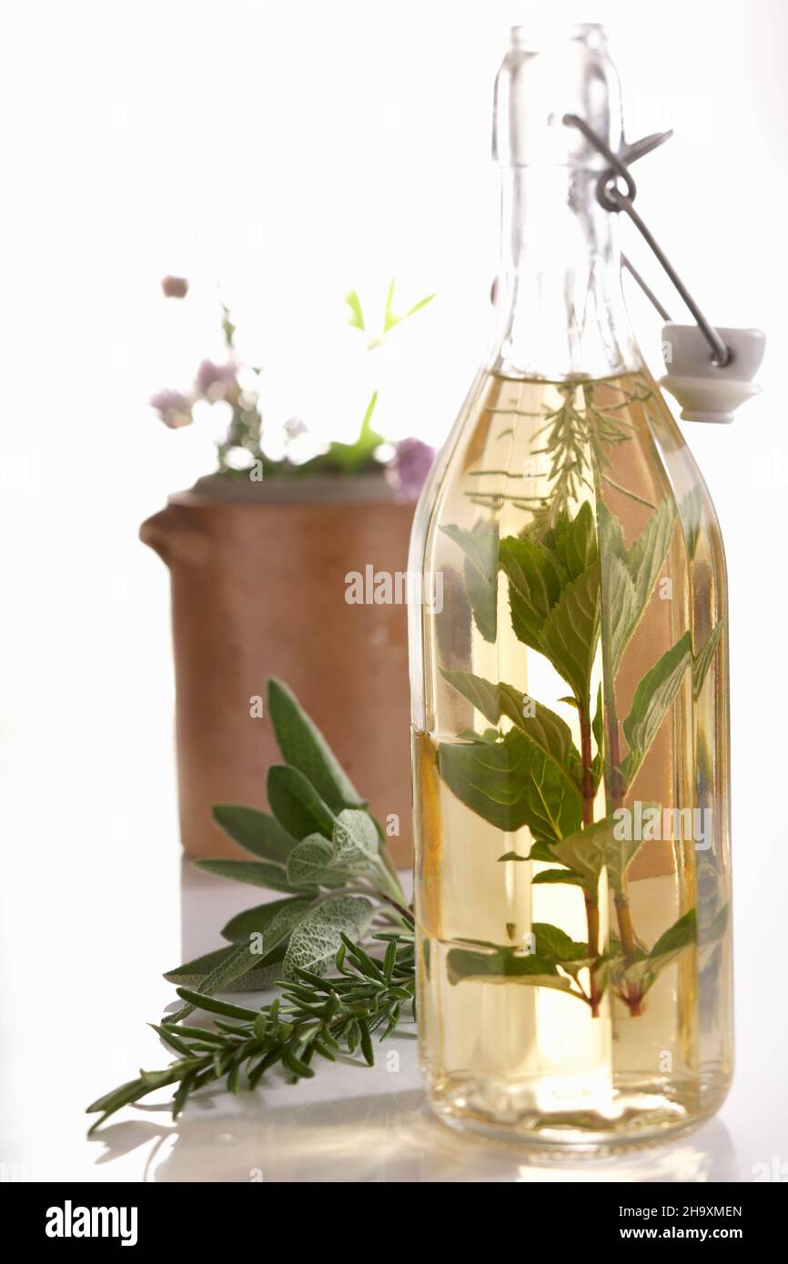 Homemade herb vinegar with fresh garden herbs in a bottle Stock Photo