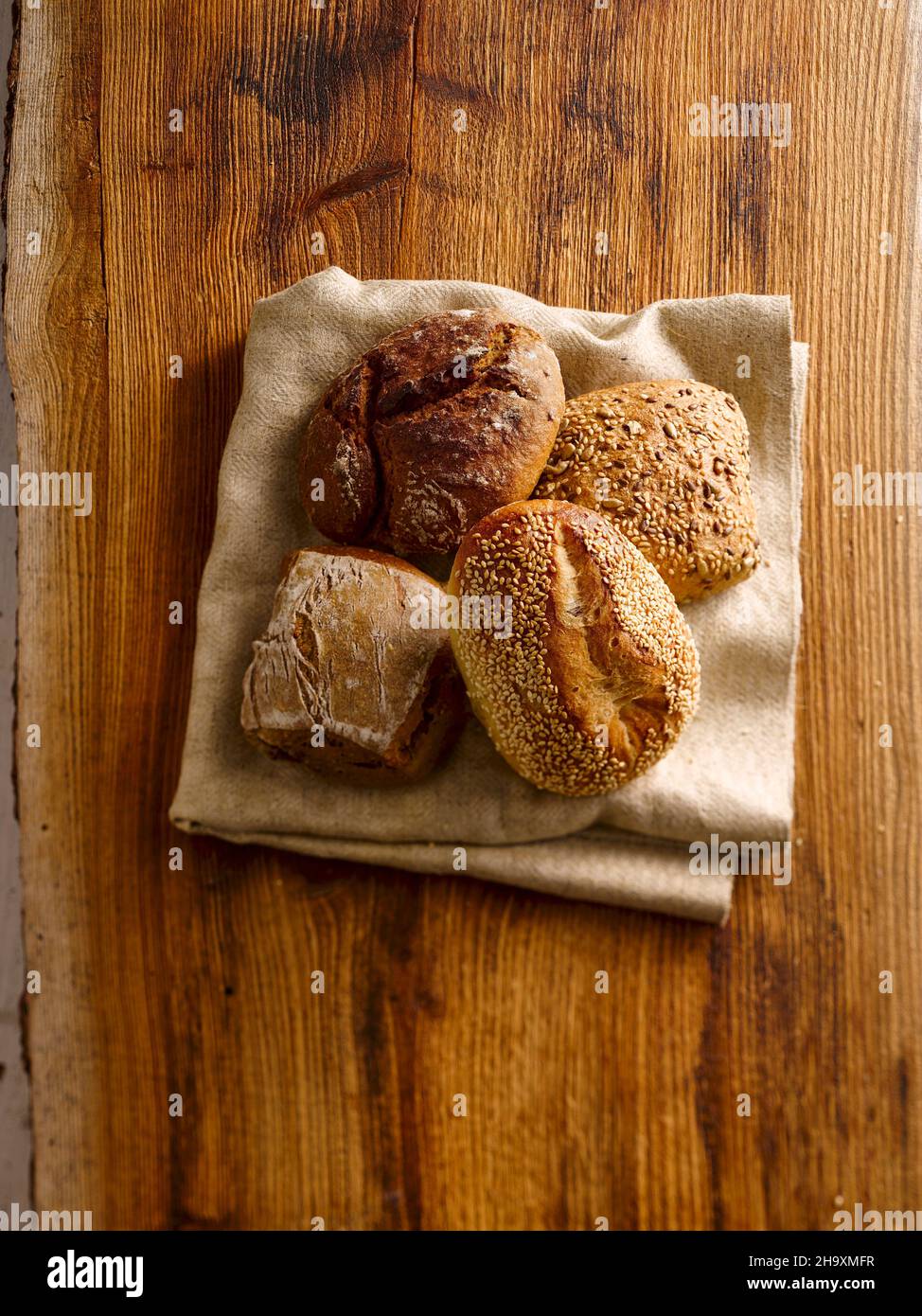 Fresh bread rolls on a folded kitchen towel Stock Photo