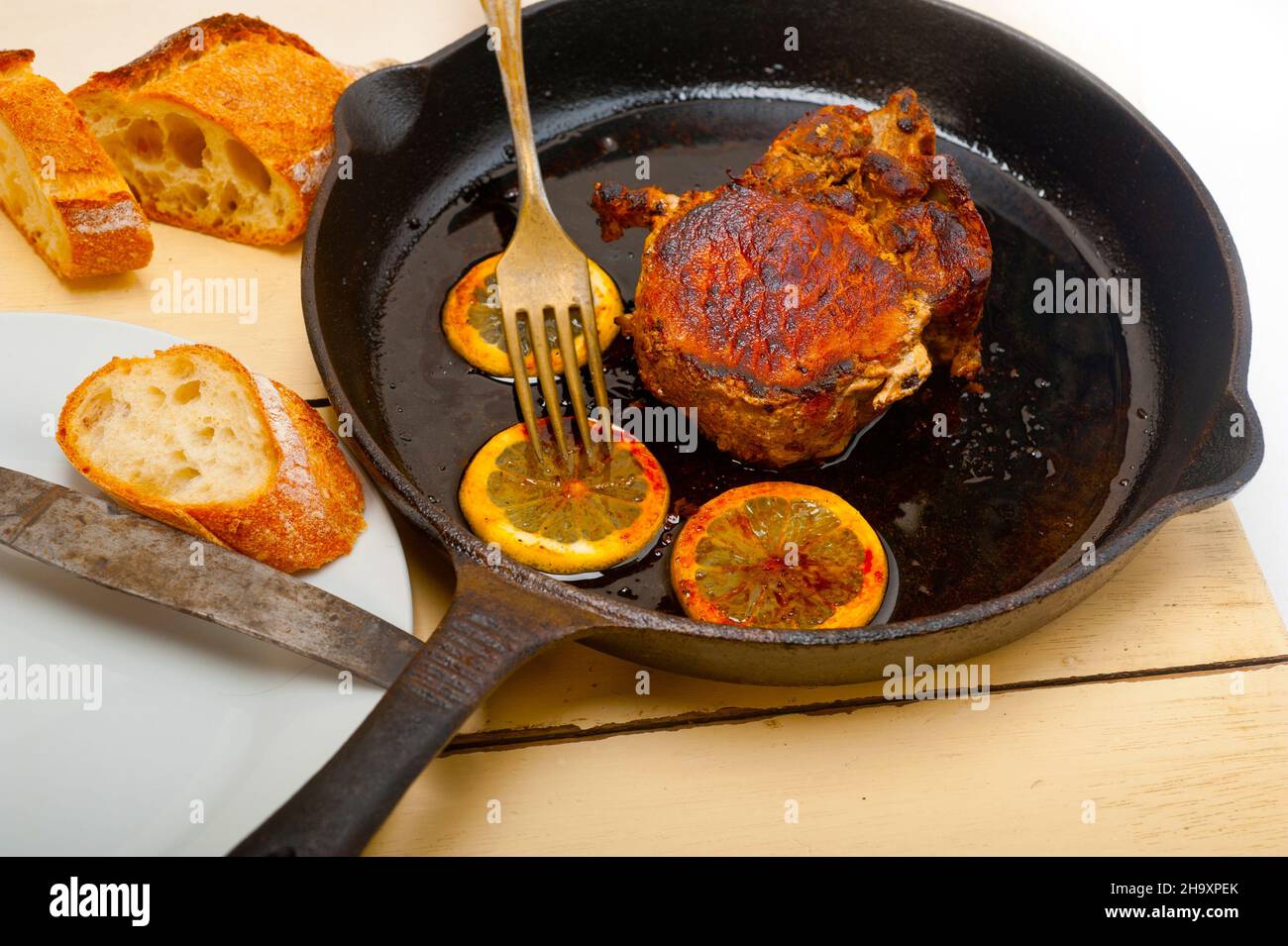 pork chop seared on iron skillet with lemon and spices seasoning Stock Photo