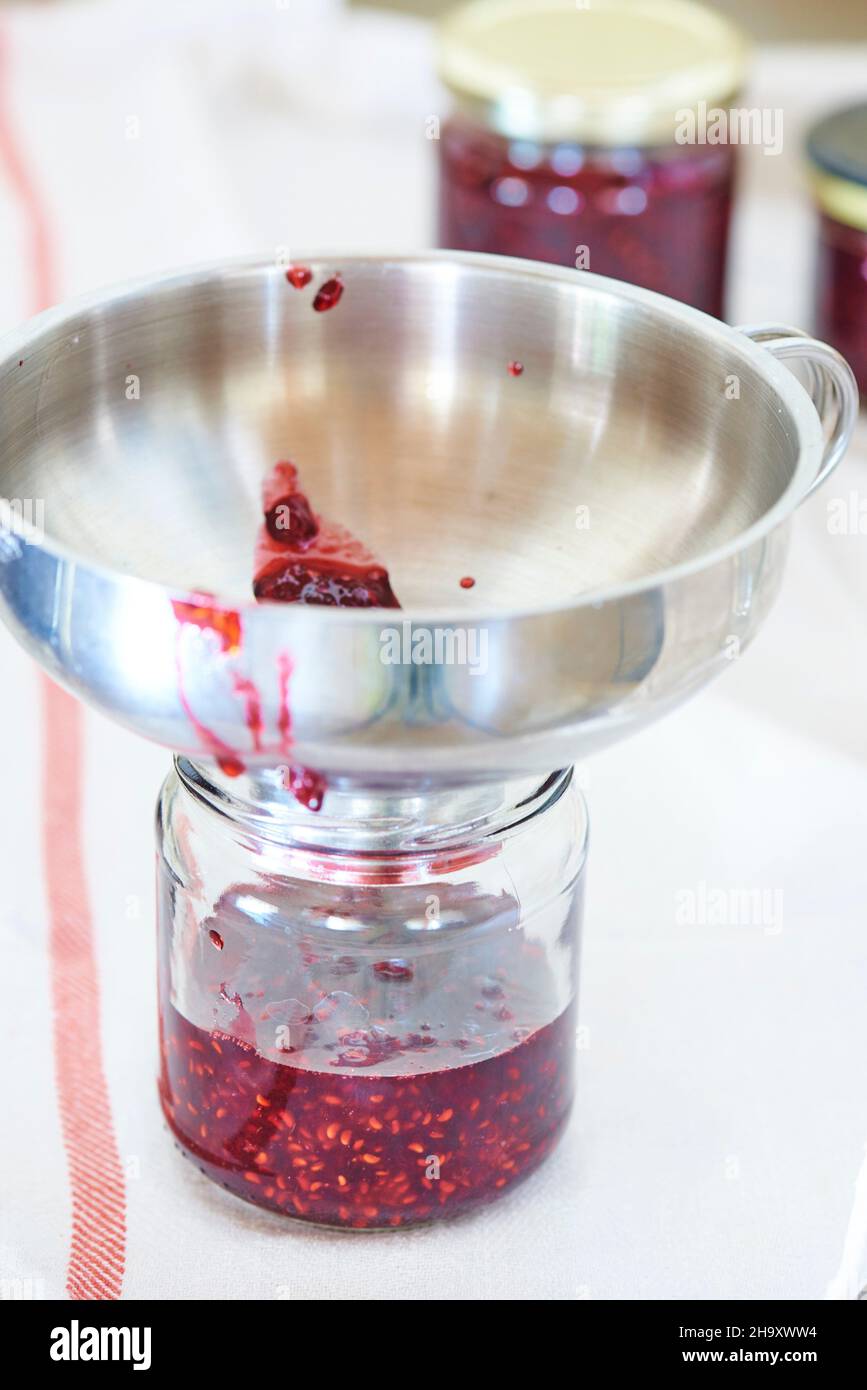 A jam jar with a metal funnel Stock Photo Alamy