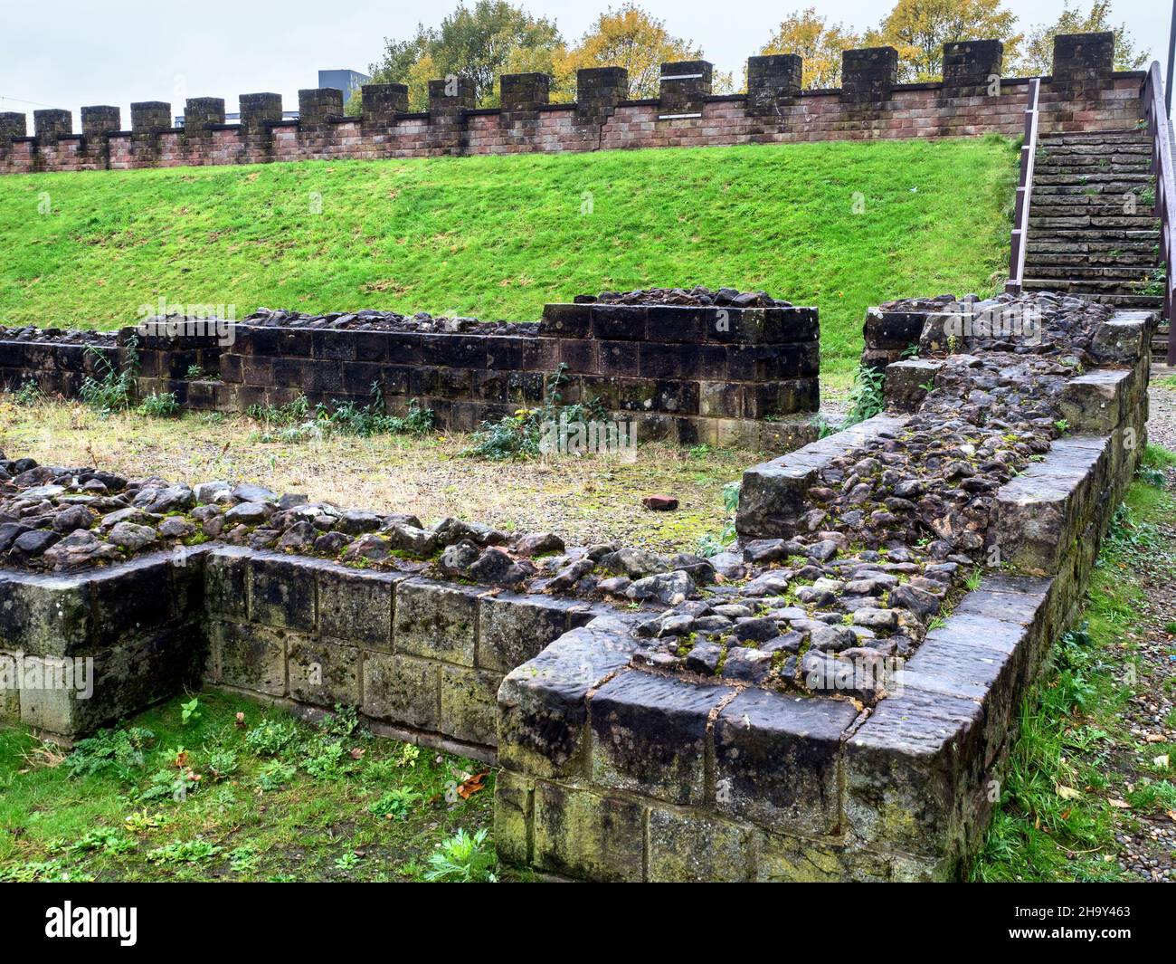 Ruins of the Roman granary with reconstructed ramparts beyond in Castlefield Manchester Greater Manchester England Stock Photo