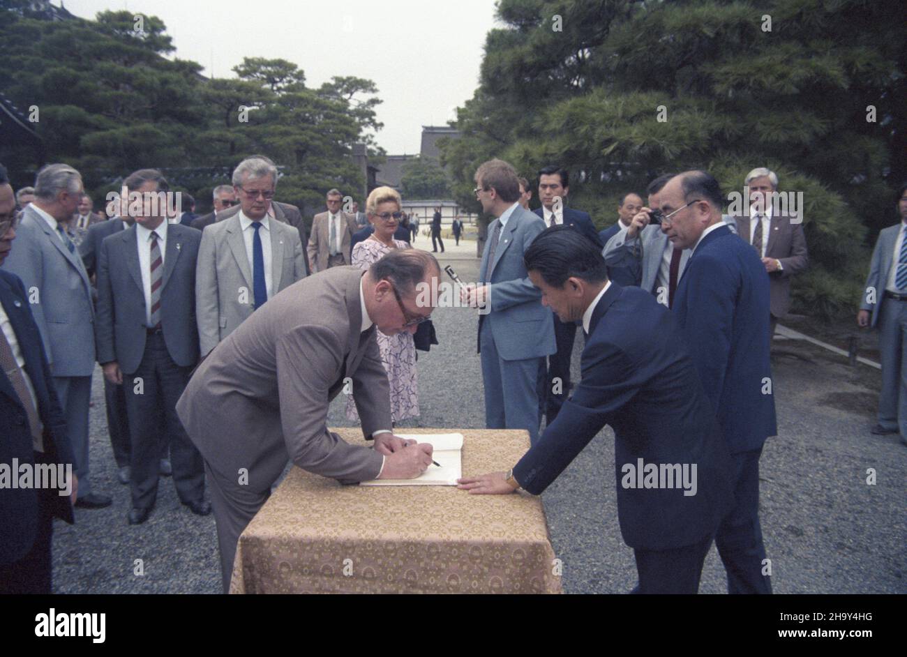 Japonia Kioto 02.07.1987. Ostatni dzieñ oficjalnej wizyty przewodnicz¹cego Rady Pañstwa PRL Wojciecha Jaruzelskiego w Japonii. Zwiedzanie dawnego pa³acu cesarskiego. Nz. m.in.: Wojciech Jaruzelski wpisuje siê do ksiêgi pami¹tkowej, minister spraw zagranicznych Marian Orzechowski (L), szef protoko³u dyplomatycznego Roman Czy¿ycki (2L) i Barbara Jaruzelska (3L). uu  PAP/Grzegorz Rogiñski       Japan Kyoto 02 July 1987. The last day of the official visit of chairman of the State Council in Japan. Visiting the former Emperor's Castle. Pictured: Wojciech Jaruzelski making an entry to the guests' bo Stock Photo