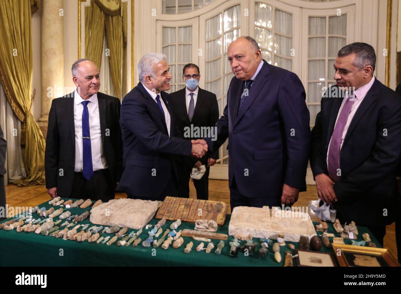 Cairo, Egypt. 09th Dec, 2021. Egyptian Foreign Minister Sameh Shoukry shakes hands with Israeli Foreign Minister Yair Lapid, during the handover of dozens of stolen Egyptian artifacts that were smuggled to Israel and were held by the Israel Antiquities Authority. Credit: Hassan Mohamed/dpa/Alamy Live News Stock Photo