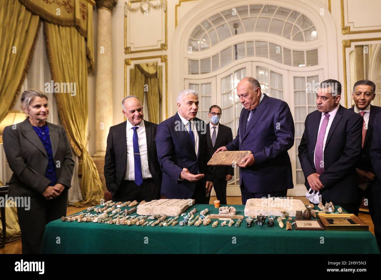 Cairo, Egypt. 09th Dec, 2021. Israeli Foreign Minister Yair Lapid presents Egyptian Foreign Minister Sameh Shoukry with one of dozens stolen Egyptian artifacts that were smuggled to Israel and were held by the Israel Antiquities Authority. Credit: Hassan Mohamed/dpa/Alamy Live News Stock Photo