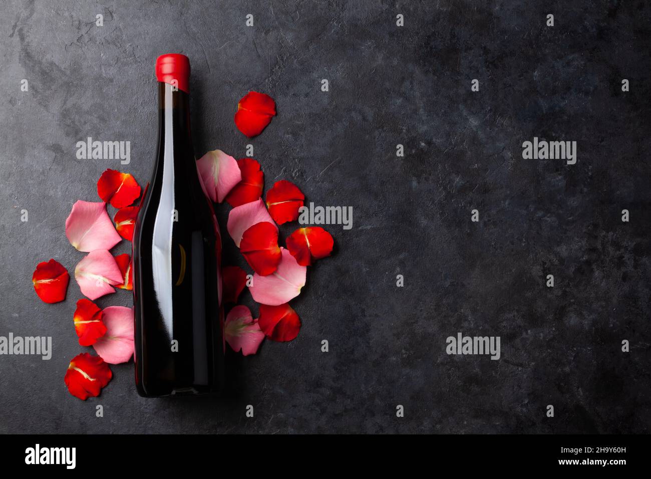 Red wine bottle and rose flower petals. Valentines day greeting card ...