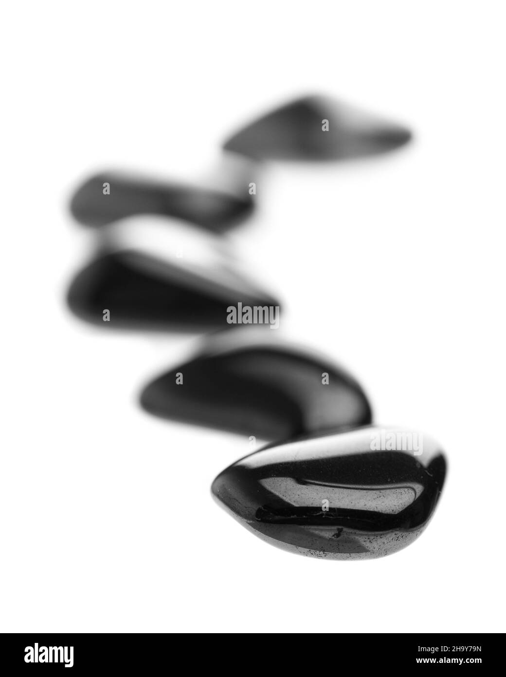 black, stones, row, line, white, background, shiny, glossy, isolated, optional, Zen, meditation, hematite, front, back, course, fuzzy, blurry, bloodst Stock Photo