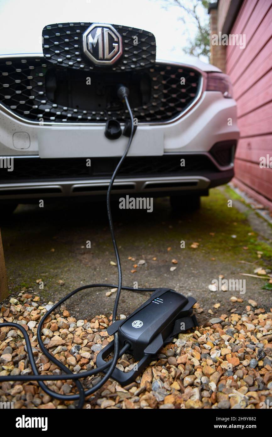 MG ZS EV charging at home with a granny charger using a extension lead, manufactures insist not to use extension leads but many users have to use them. Stock Photo