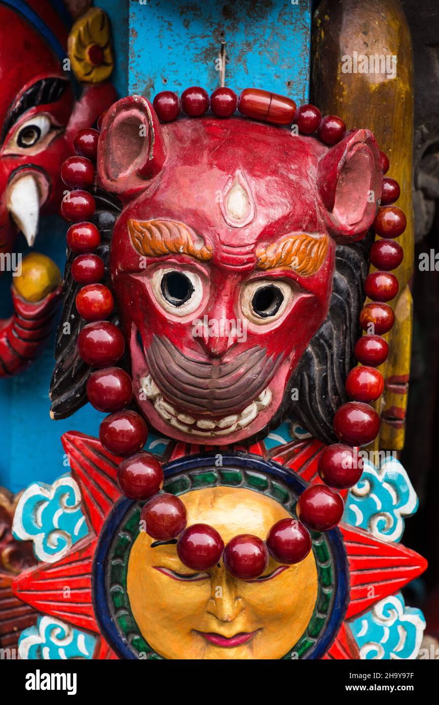A carved wooden Hanuman mask for sale in a vendor's stall in the