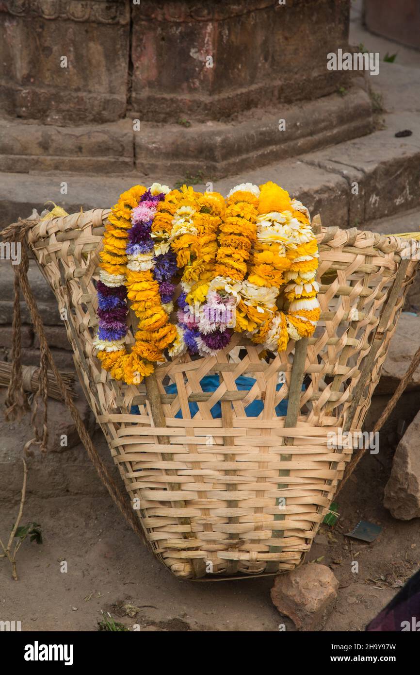 Flower garlands in a split bamboo basket for sale as offerings in the