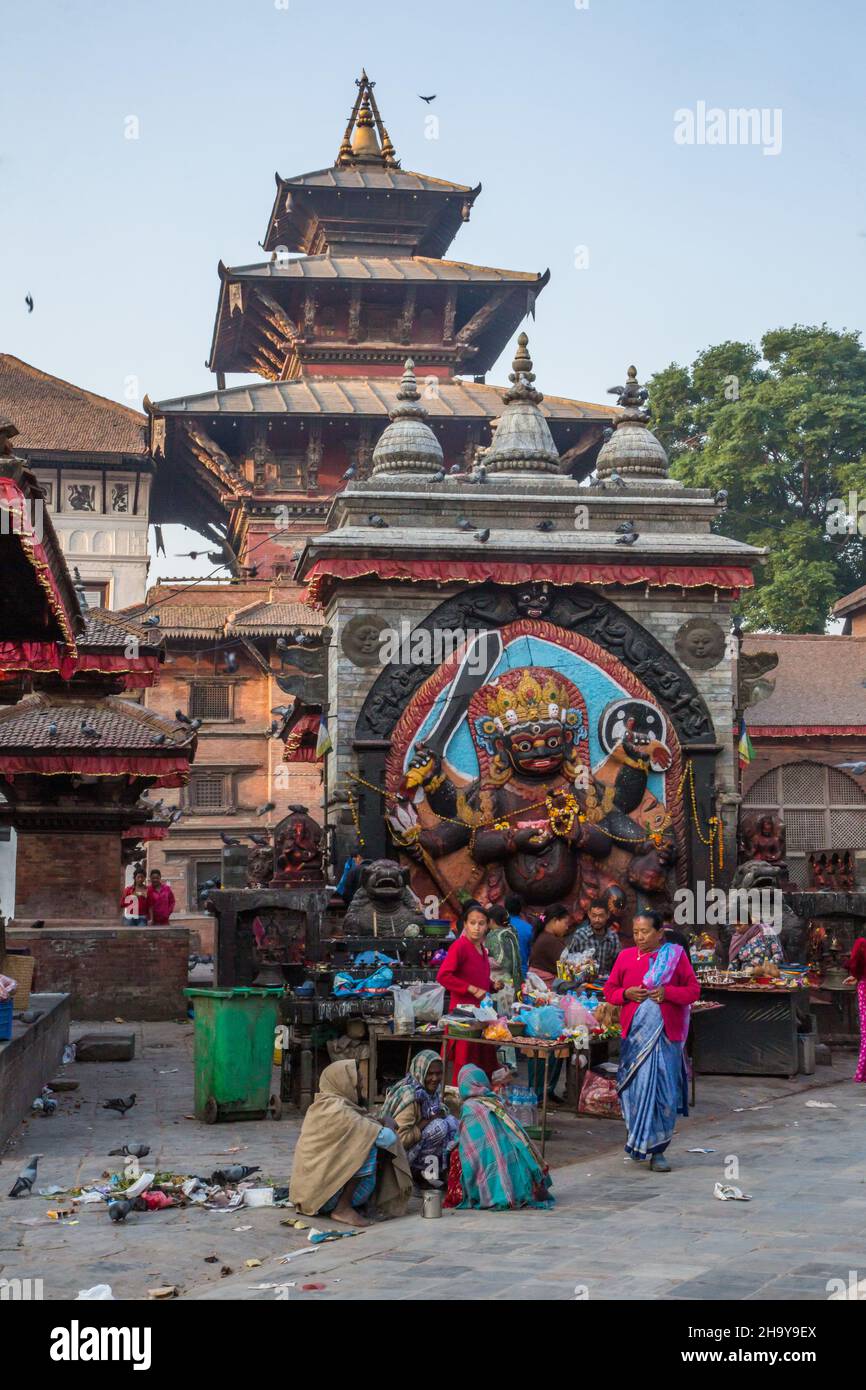 Hindu worshippers make offerings at the Hindu shrine of the Kala or Black Bhairab in Durbar Square, Kathamandu, Nepal. The Black Bhairab is the destr Stock Photo