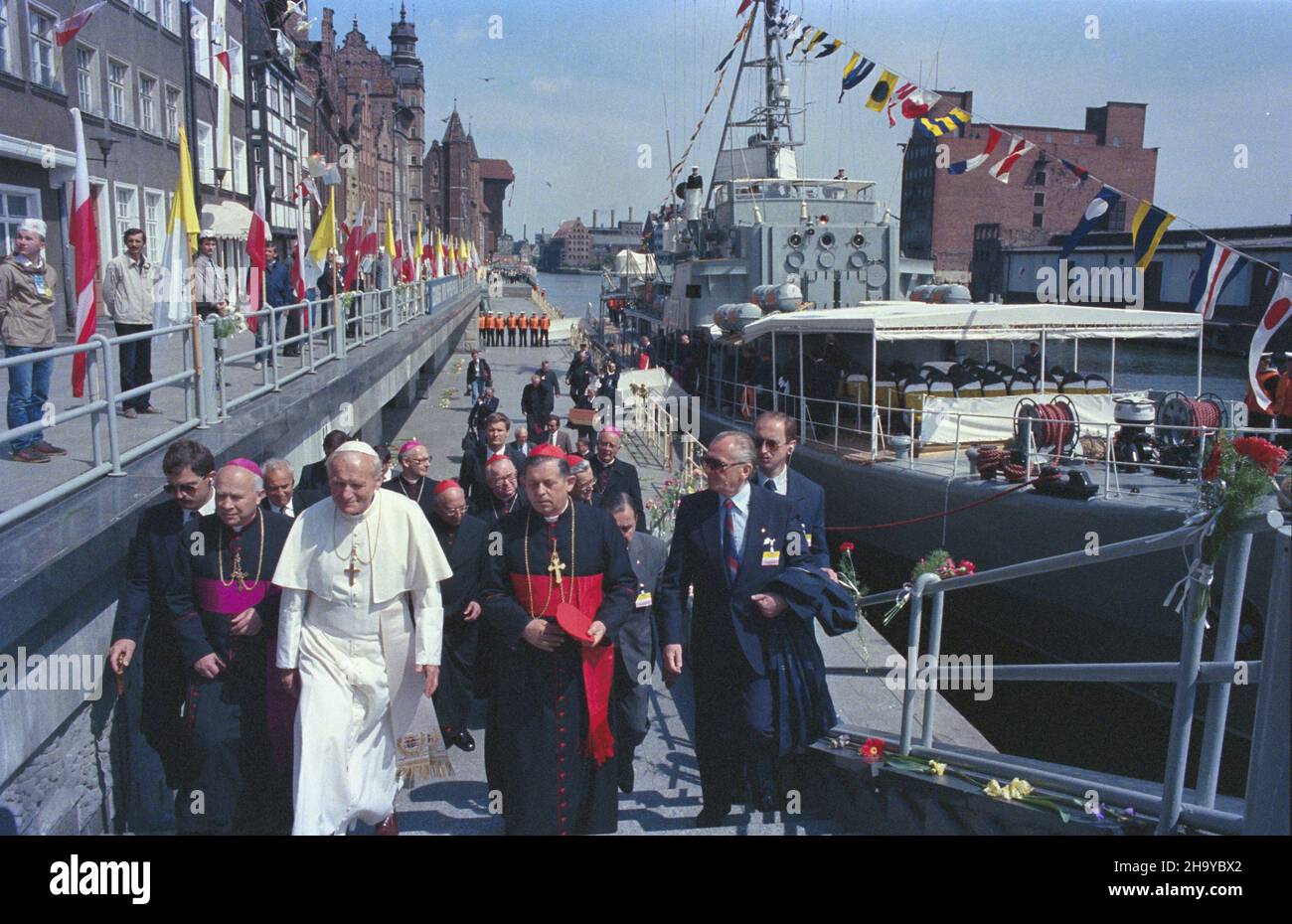 Gdañsk 12.06.1987. III pielgrzymka papie¿a Jana Paw³a II do Polski. Nz. Ojciec Œwiêty opuœci³ pok³ad tra³owca Polskiej Marynarki Wojennej ORP Mewa i udaje siê na spotkanie z chorymi w gdañskiej Bazylice Mariackiej. Papie¿owi towarzysz¹ m.in. prymas Polski kard. Józef Glemp (3P), biskup diecezjalny diecezji gdañskiej Tadeusz Goc³owski (2L), funkcjonariusz Biura Ochrony Rz¹du Miros³aw Gawor (1L). ka  PAP/Wojciech Kryñski         Gdansk, 12 June 1987. Pope John Paul II on his third pilgrimage to Poland. Pictured: the Holy Father leaves the Polish Navy's minesweeper Mewa underway to a meeting with Stock Photo