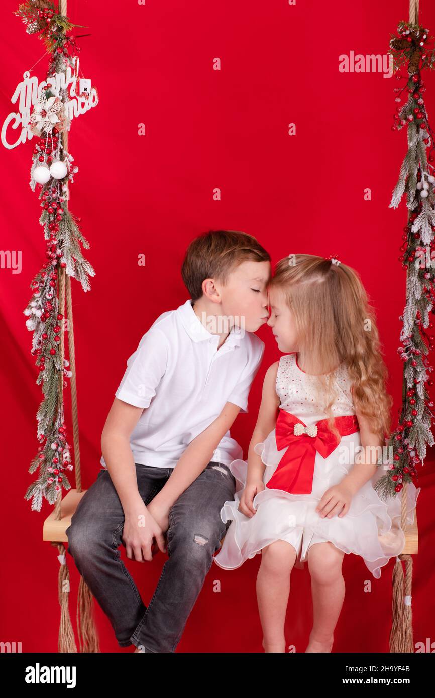 boy and girl - sister and brother - sitting on a swing decorated with ...