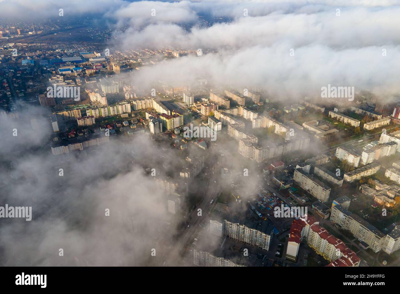 Top aerial view of fluffy white clouds over modern city with high rise ...