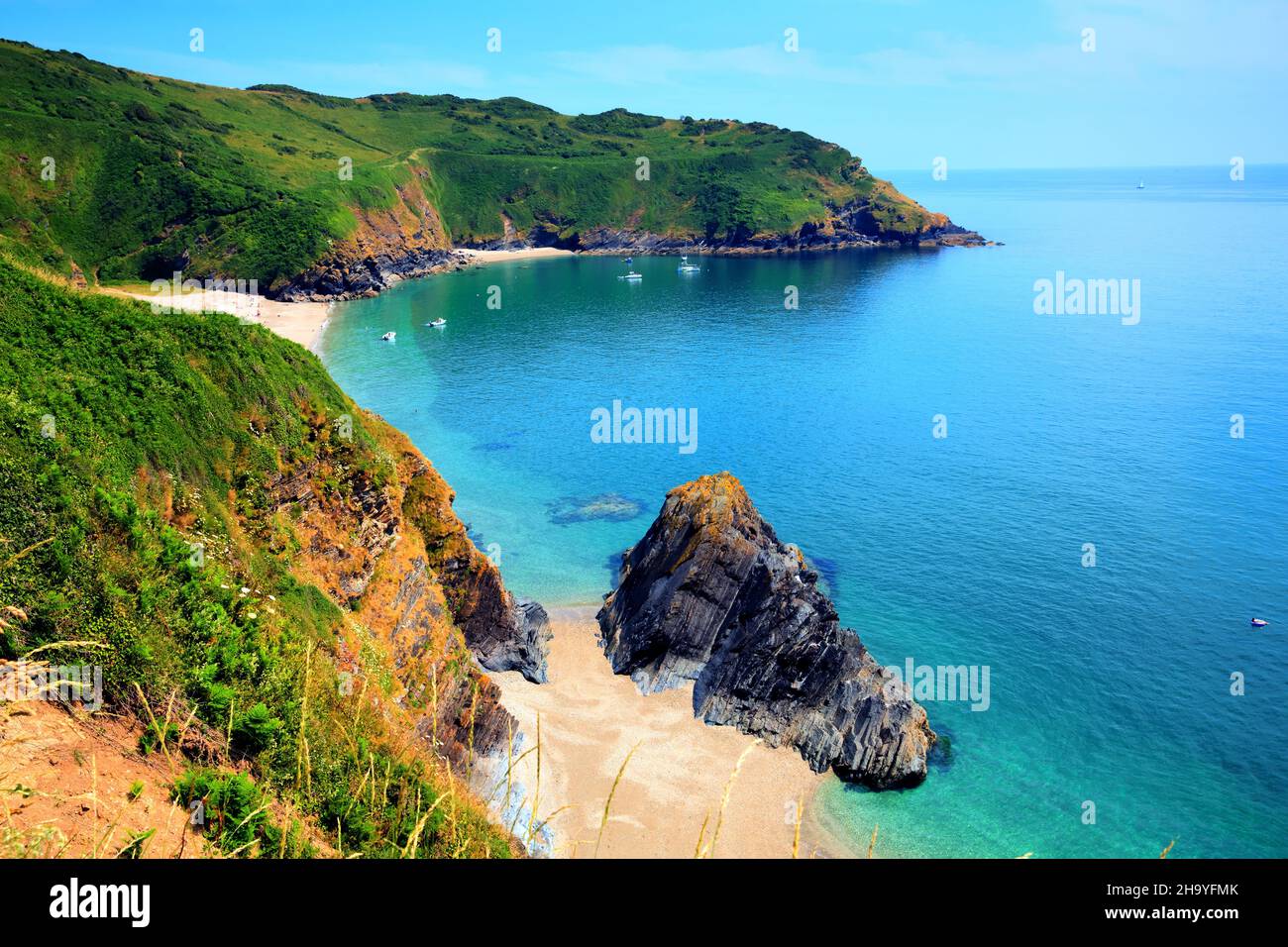 Lantic Bay Cornwall beautiful UK secluded beach with blue turquoise sea and yachts Stock Photo