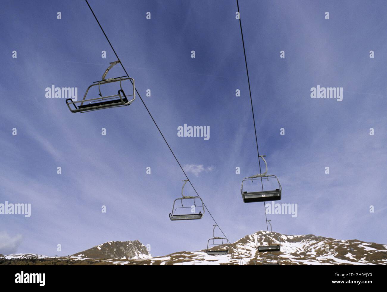 Empty chairlifts hanging on cables, Tonale, Italy Stock Photo