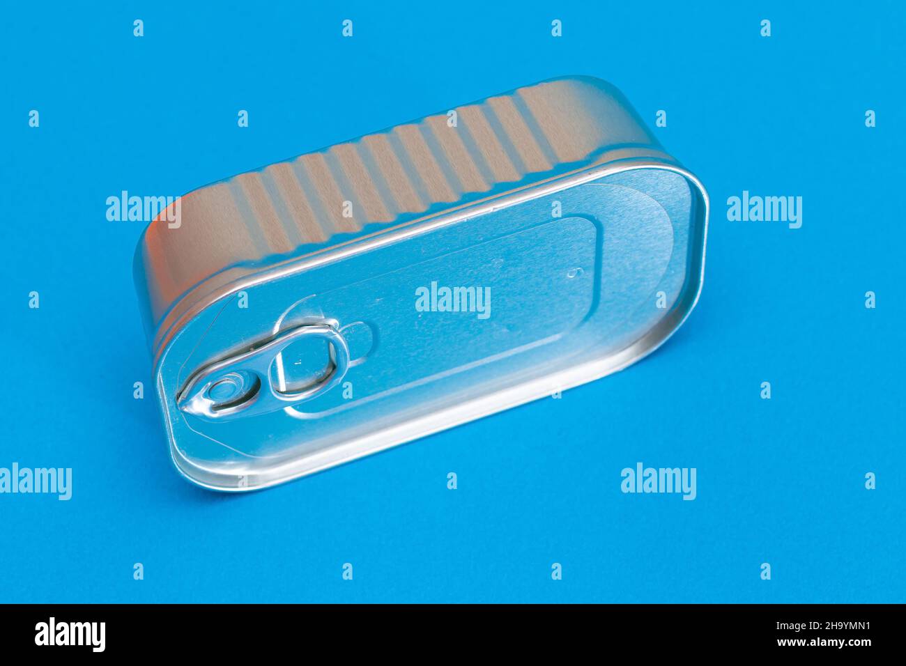 Unopened Tin Can with Blank Edge on Light Blue Background. Canned Food