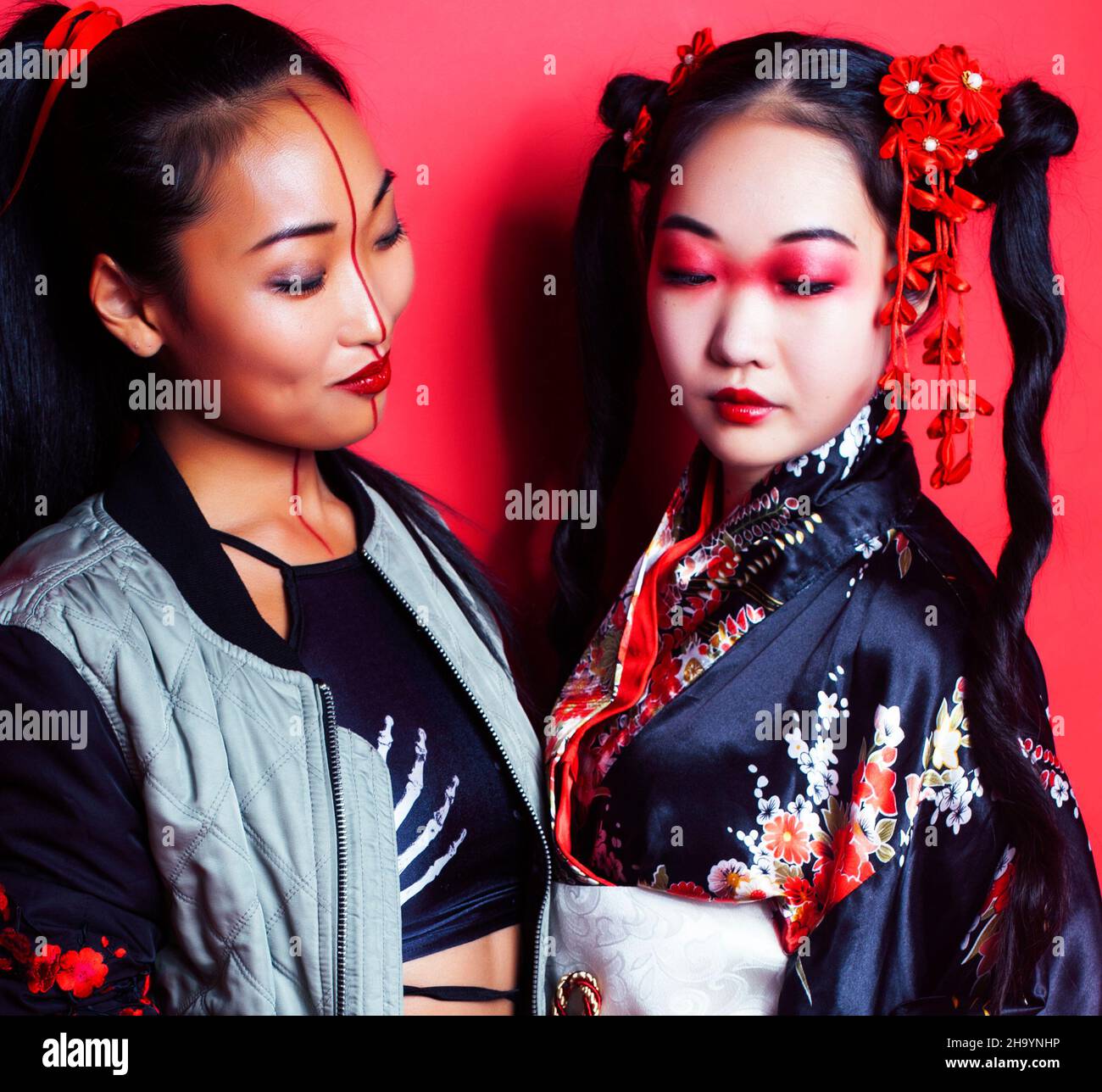 two pretty geisha friends: modern asian woman and traditional wearing ...