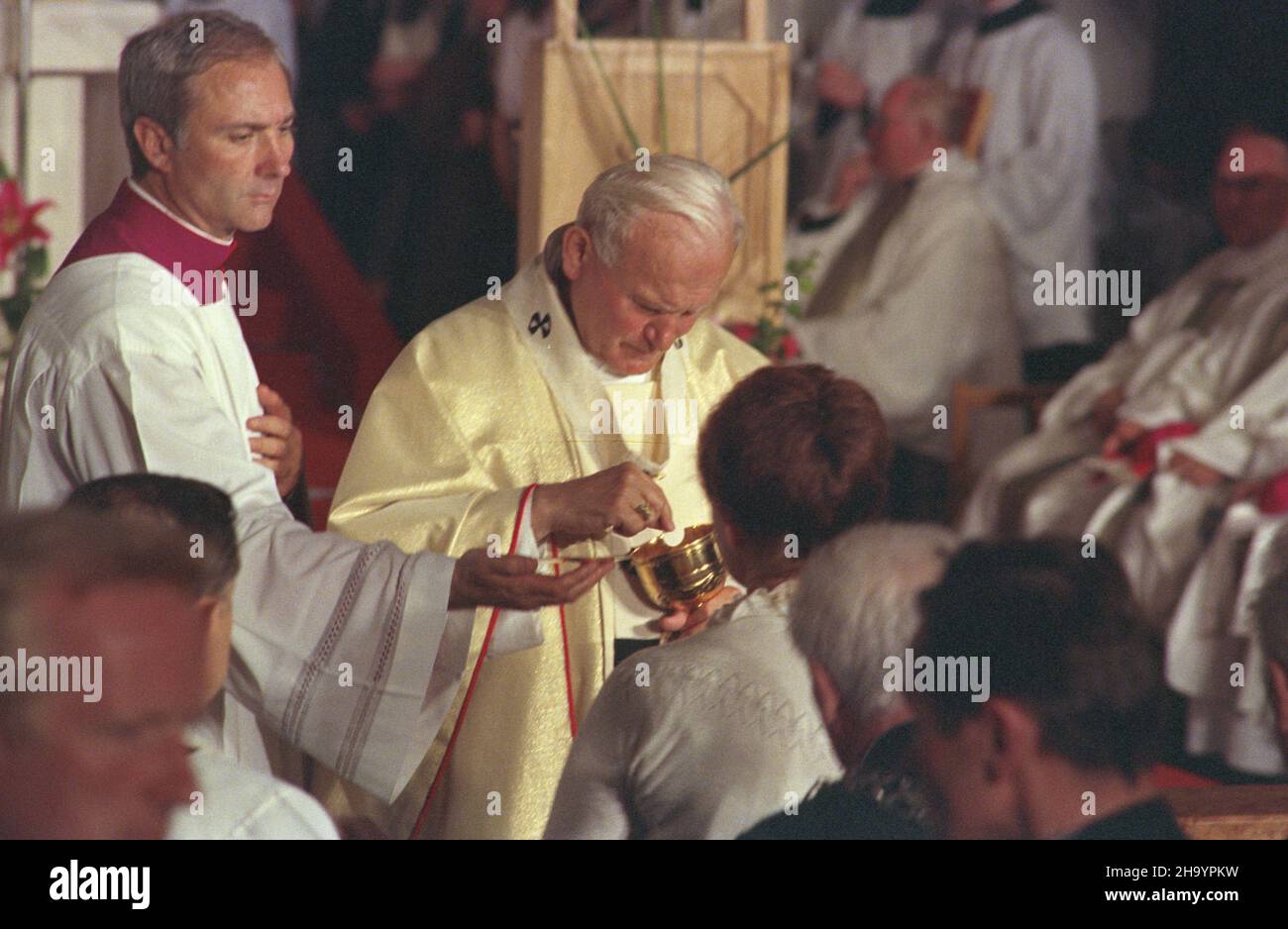 Warszawa 08.06.1987. III pielgrzymka papie¿a Jana Paw³a II do Polski. Nz. Ojciec Œwiêty udziela komunii œwiêtej po mszy œwiêtej podczas inauguracji II Kongresu Eucharystycznego, w koœciele pw. Wszystkich Œwiêtych przy placu Grzybowskim. U boku Jana Paw³a II Mistrz Papieskich Ceremonii Liturgicznych pra³at Piero Marini. ka  PAP/Grzegorz Rogiñski         Warsaw, 8 June 1987. Pope John Paul II on his third pilgrimage to Poland. Pictured: the Holy Father celebrates Holy Communion after a Holy Mass at the opening of the Second Eucharistic Congress in All Saints' Church on Grzybowski Square. Next to Stock Photo