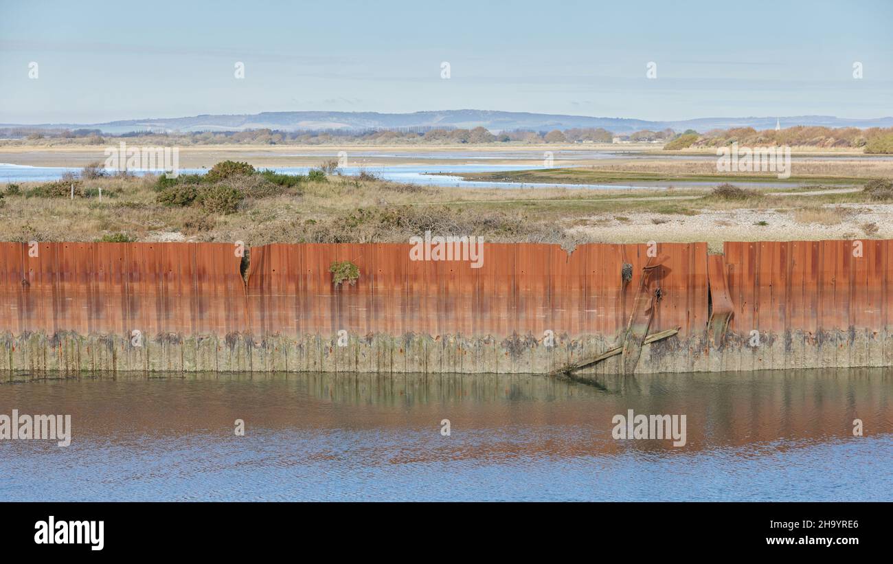Remnants of an old rusted metal structure seen in the landscape of Pagham Harbour. Stock Photo