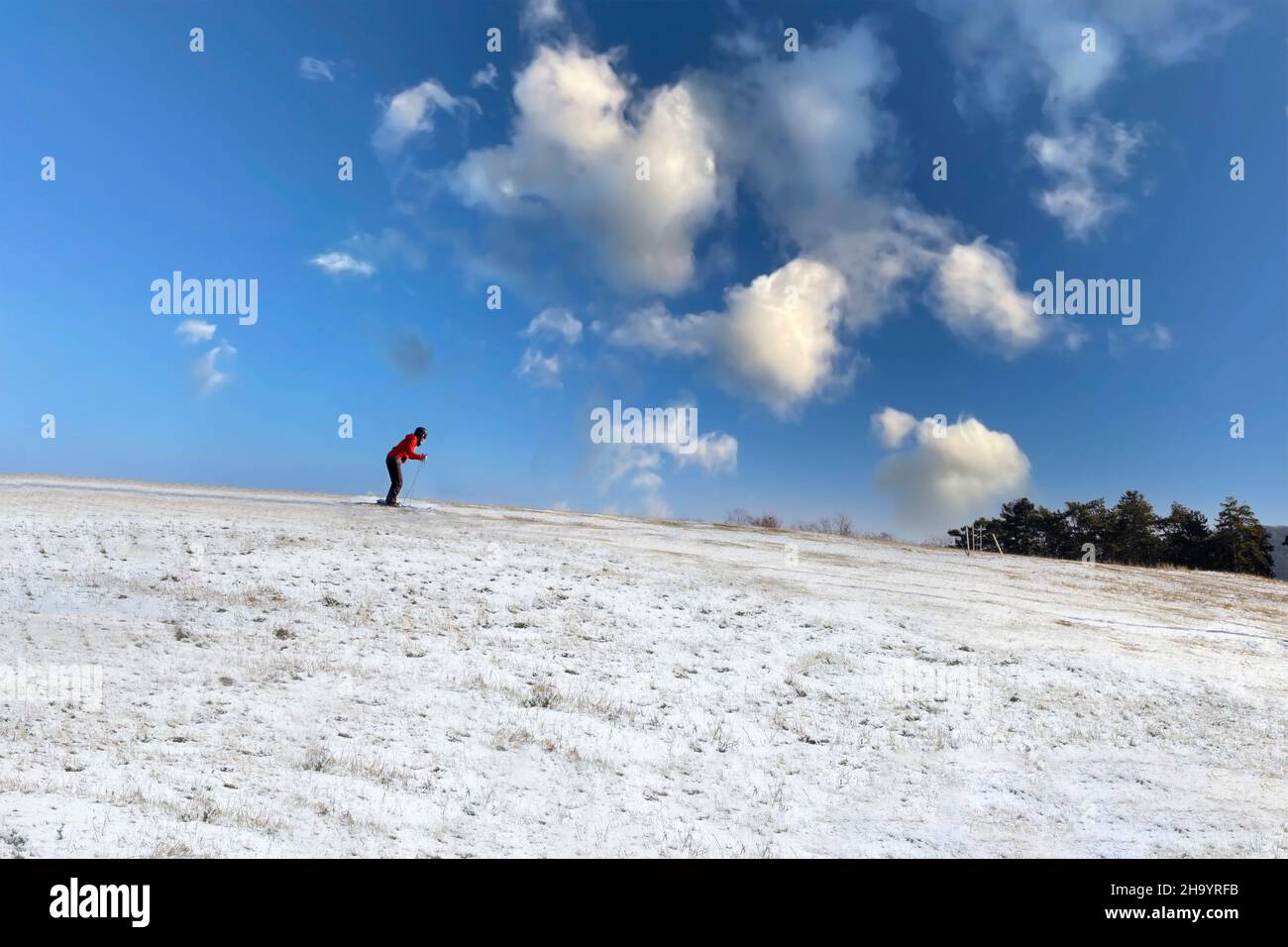 Skiing down the mountain on a sunny day Stock Photo