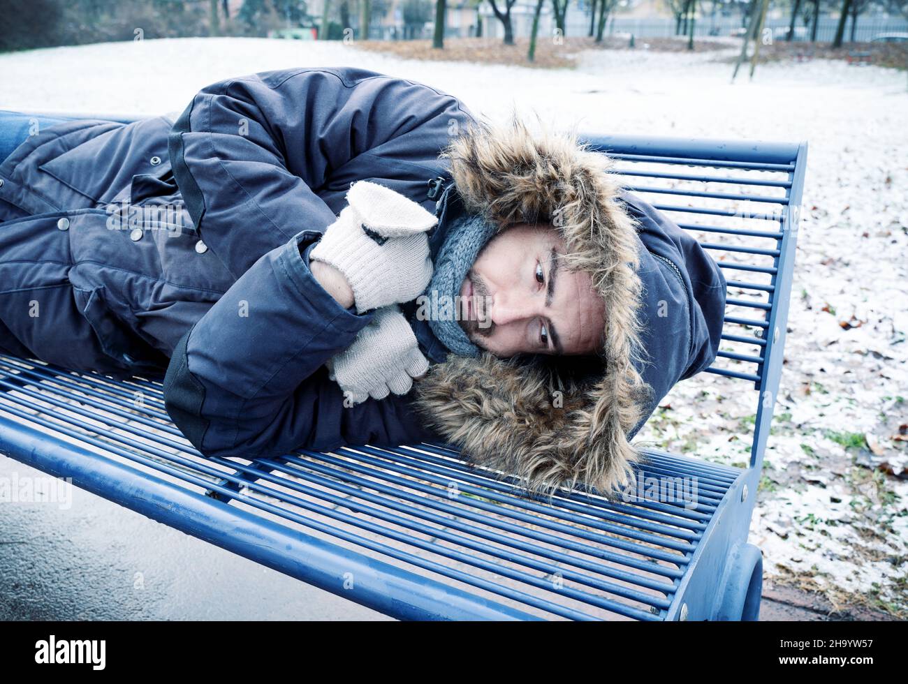 Poor homeless man suffering cold during winter weather season Stock