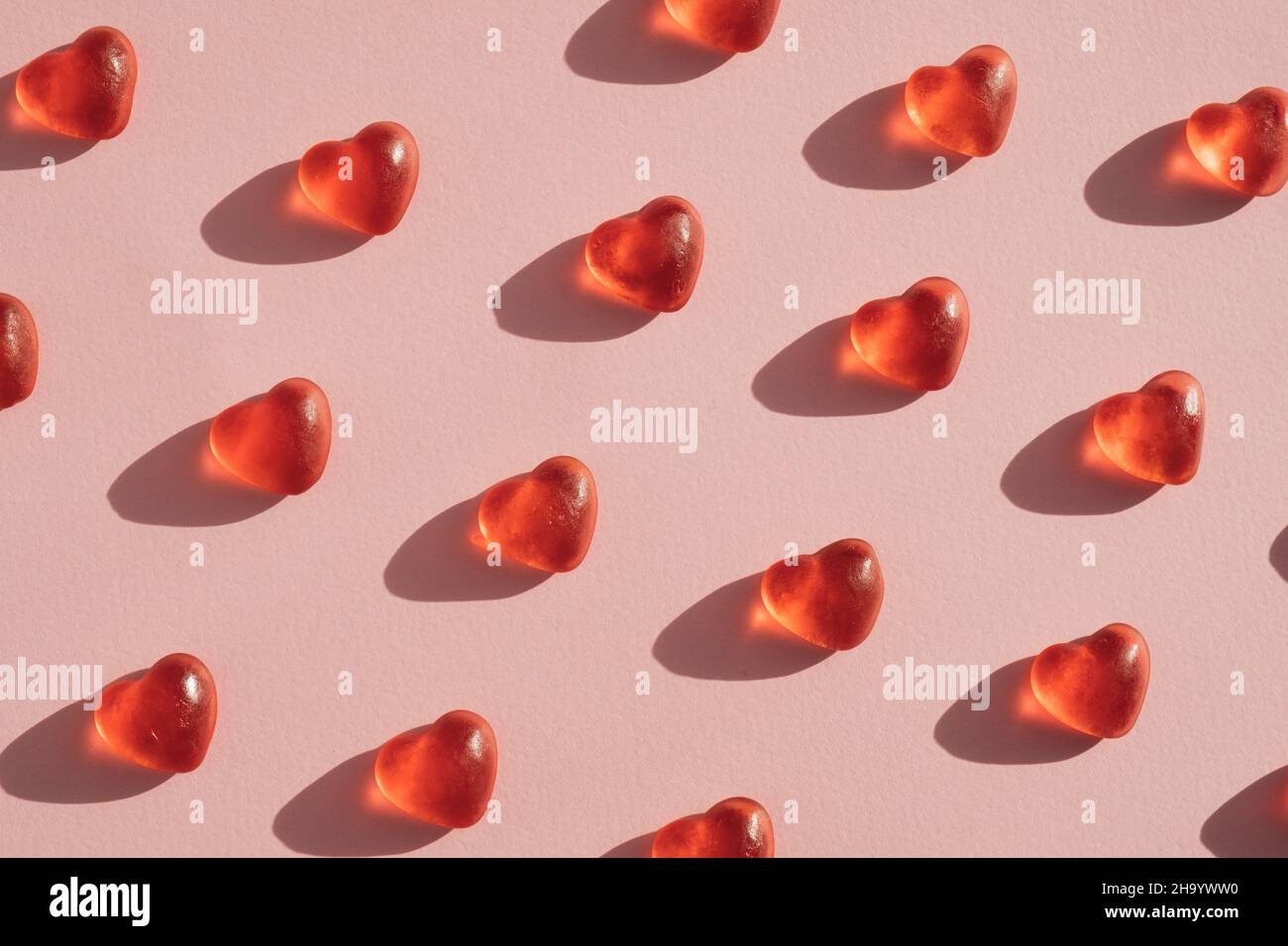 Gummy heart shaped candy layout against pink coral background. Valentines day concept Stock Photo