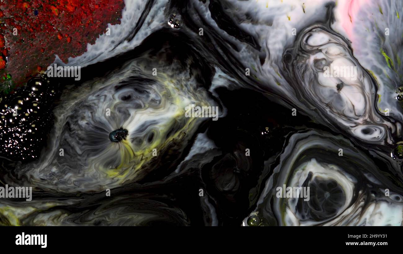 Bubbling Ink Texture Close-up of bubbling black ink. On colorful surface of milk with paint ...