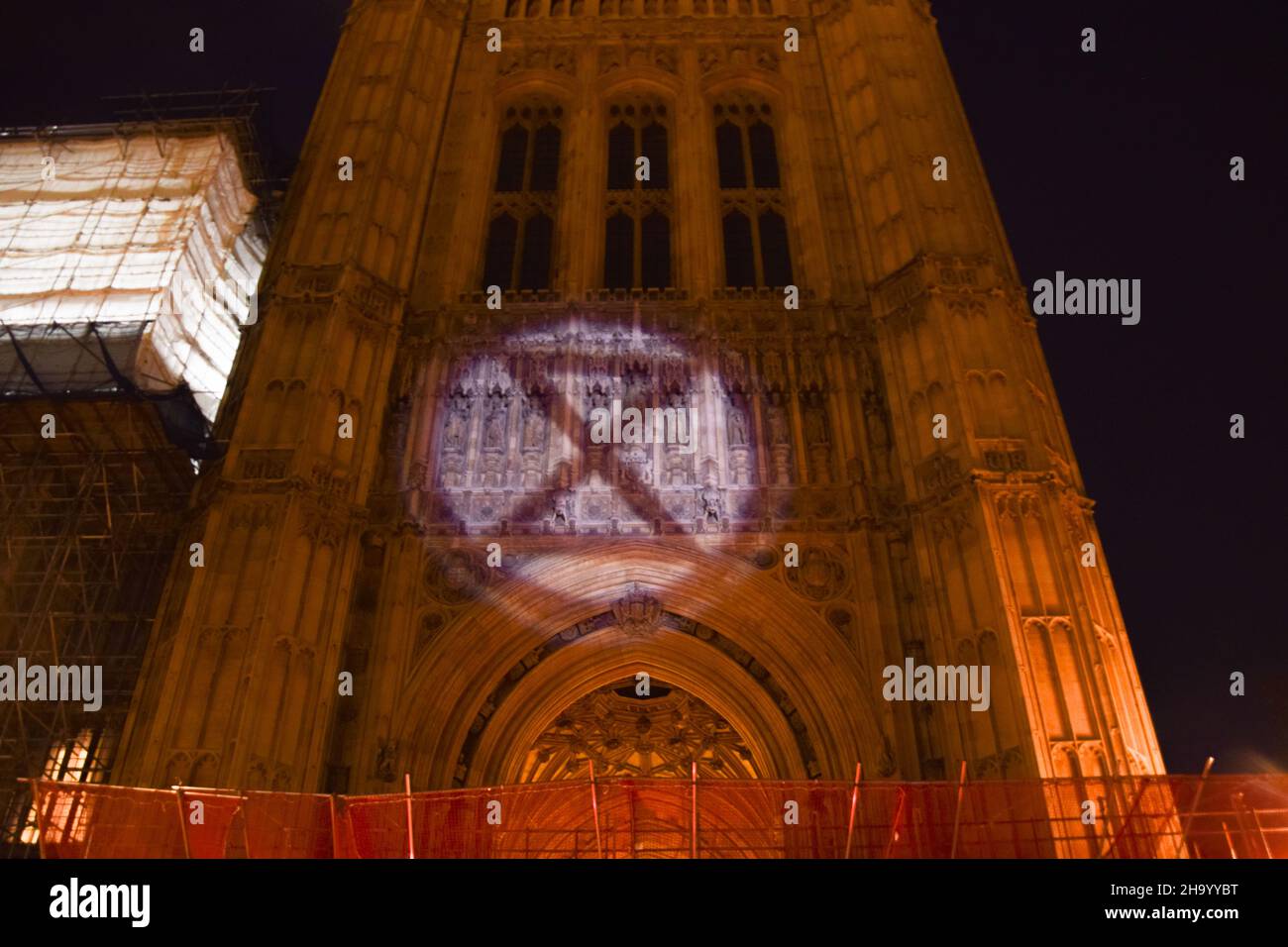 London, UK. 8th December 2021. Protesters project the Extinction Rebellion symbol on the Palace of Westminster. Kill The Bill demonstrators gathered outside the Houses of Parliament in protest against the Police, Crime, Sentencing and Courts Bill. Stock Photo