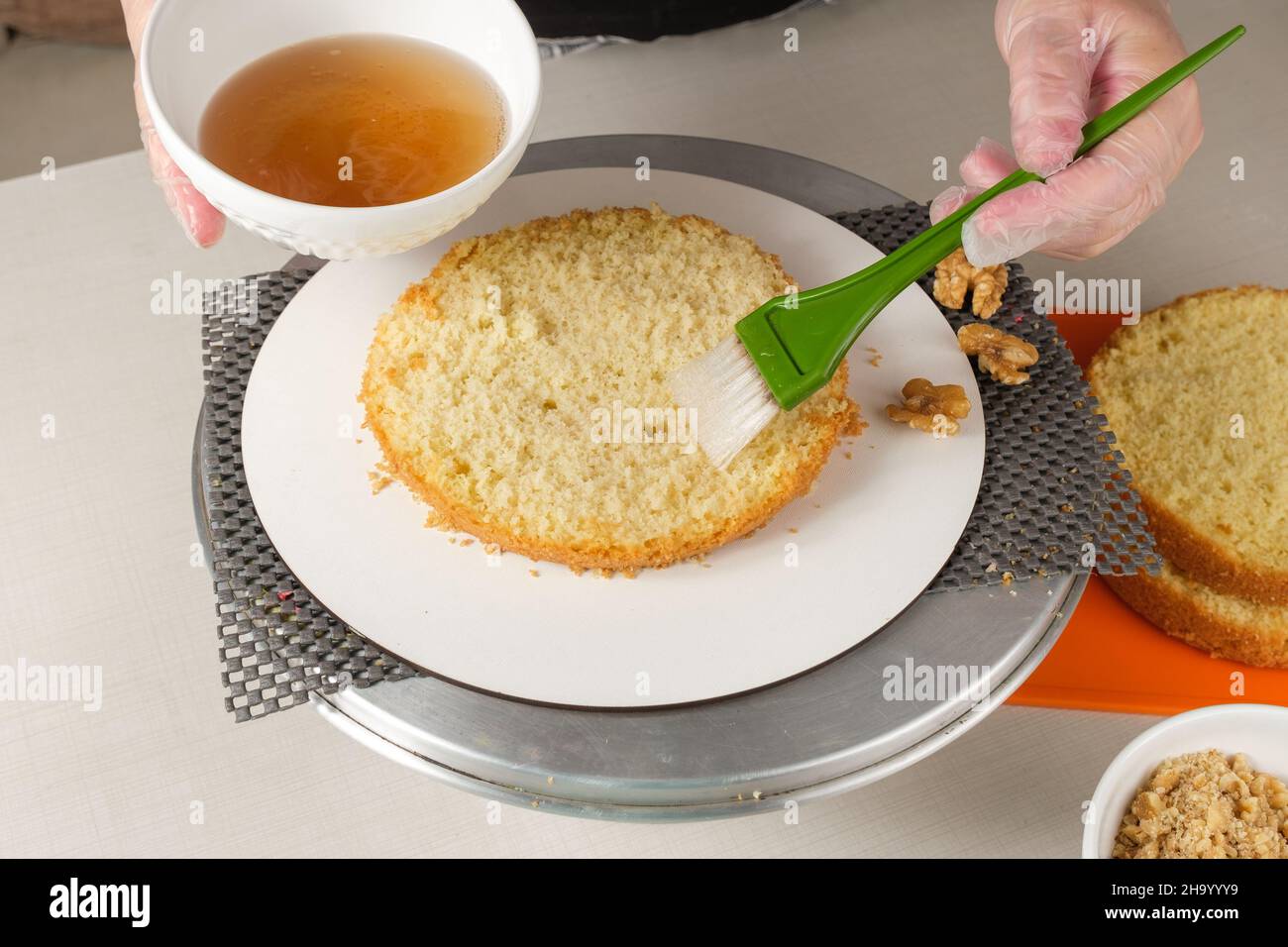 Confectioner moistening cake batter with soda before adding the filling