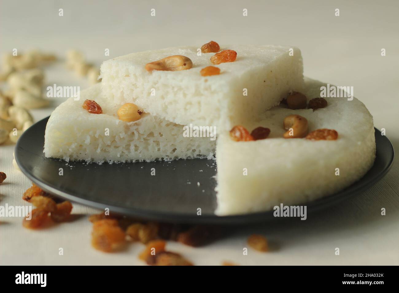 Vattayappam. Steamed rice cake made of sweet fermented batter of rice and coconut, topped with raisins while steaming. Traditional snack from south ke Stock Photo