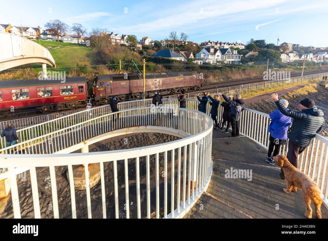 Vintage Class 47 diesel locomotive on an enthusiast special charter passing enthusiasts on Gypsy Bridge at Chalkwell, Essex, UK. Waving public Stock Photo