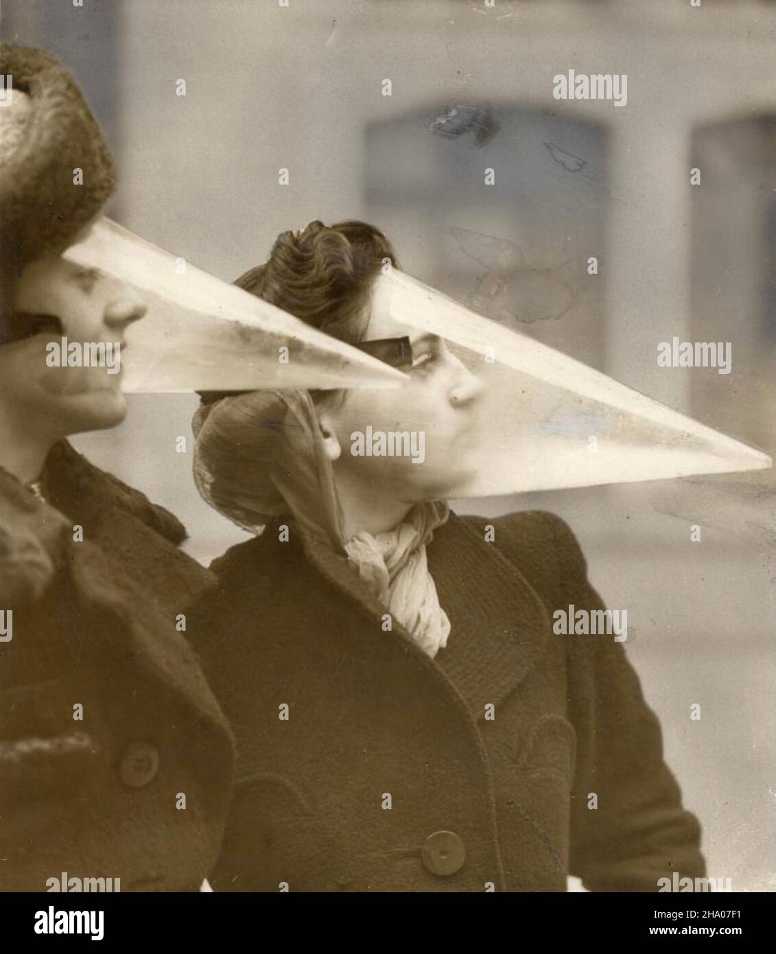 Two woman and their plastic face protection from snowstorms - Montreal, Canada - 1939 - makes kissing difficult Stock Photo