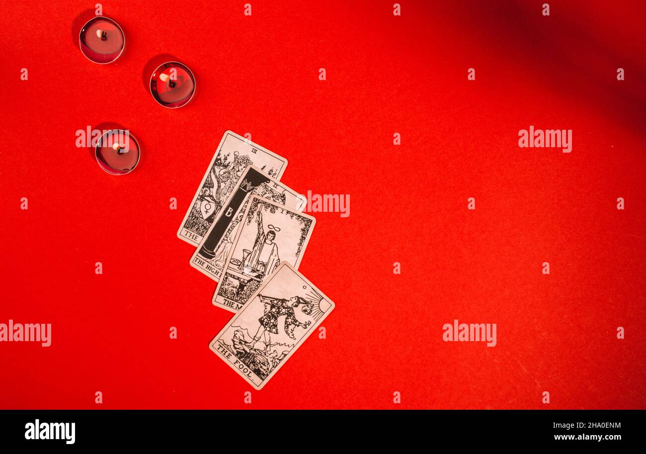 Tarot cards on red background, occult and magic Stock Photo